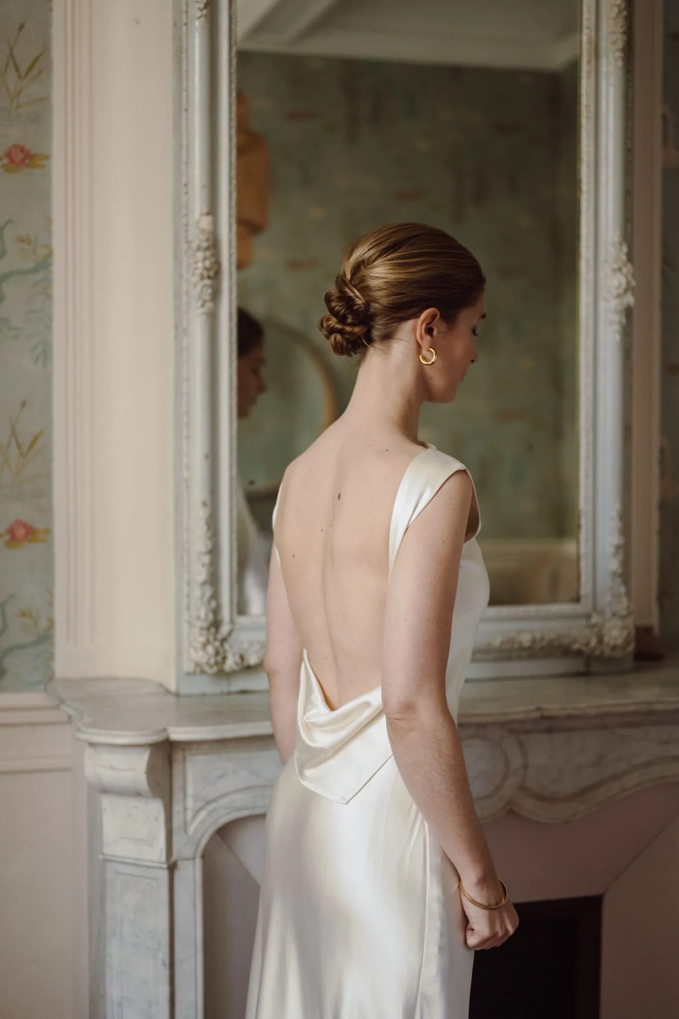 Mariée devant un miroir, coiffure attachée vue de dos